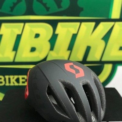 Capacete de bicicleta preto com detalhes vermelhos e texto SCOTT