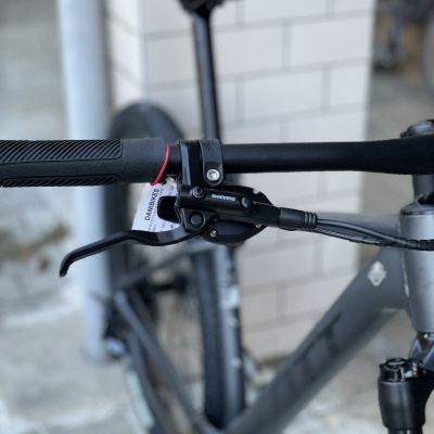 Guiador e alavanca de travão de bicicleta preta com etiqueta e quadro cinzento