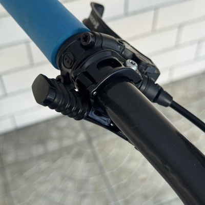 Punho de bicicleta azul e alavanca de mudança de velocidades preta num guiador preto
