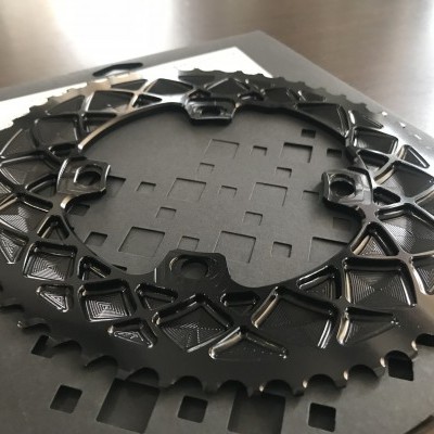 duas coroas pretas de bicicleta em metal sobre caixa preta