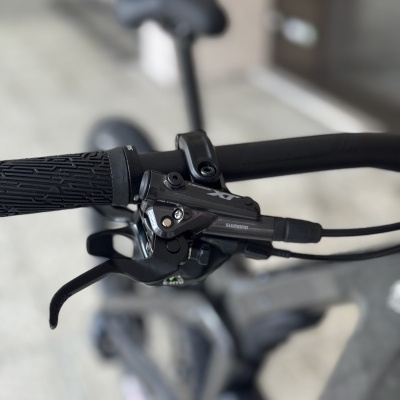 Detalhe do guiador e manete de travão Shimano Deore XT numa bicicleta
