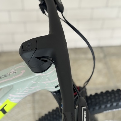 Guiador preto de bicicleta com quadro verde claro e detalhes amarelos e pneu robusto.