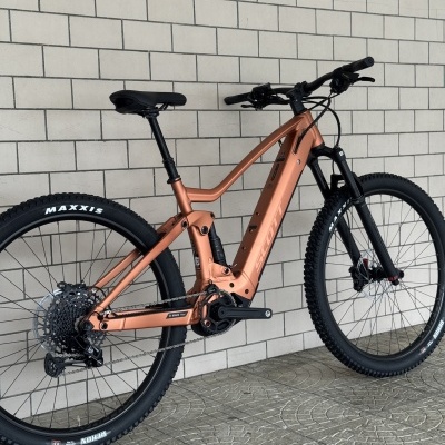 Bicicleta eléctrica de montanha cor cobre metálico com pneus Maxxis dianteiro e traseiro