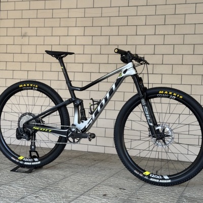 Bicicleta de montanha Scott cinza e preta com pneus Maxxis e suspensão RockShox