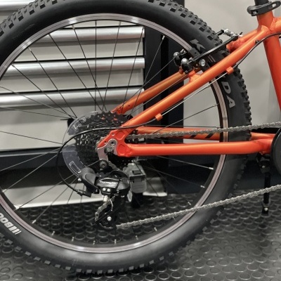 Roda traseira de bicicleta laranja com engrenagem e corrente