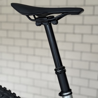 Selim e espiga de selim de bicicleta com parede de azulejos ao fundo