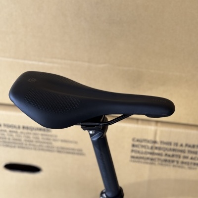 Selim de bicicleta preto com textura antiderrapante sobre tija de selim preta