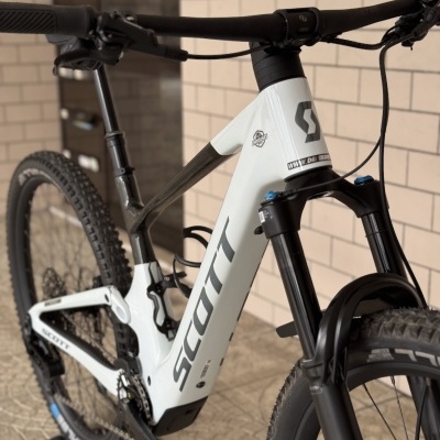 Bicicleta de montanha SCOTT branca e preta encostada a parede.