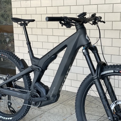 Bicicleta de montanha eléctrica preta com pneus Maxxis e suspensão Fox