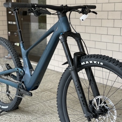Bicicleta de montanha azul escura com rodas Maxxis e garfo RockShox