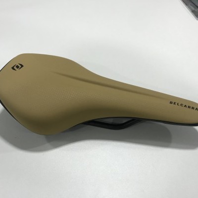 Selim de bicicleta bege BEL-CARRA com estrutura preta sobre fundo branco