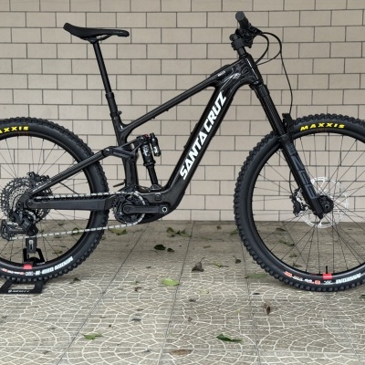 Bicicleta de montanha elétrica preta Santa Cruz com suspensão e pneus Maxxis