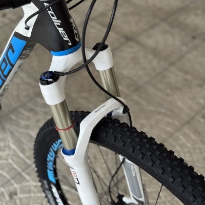 Bicicleta de montanha com suspensão RockShox e pneus de cravos