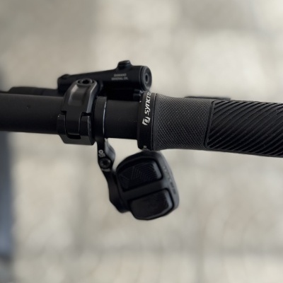 Punho de bicicleta preto com manete de travão e botão de controlo