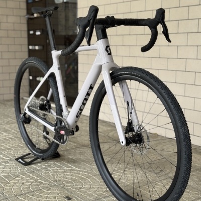 Bicicleta de estrada branca e preta SCOTT com pneus texturizados e travões de disco