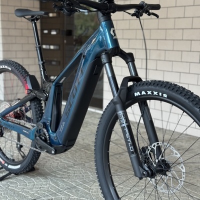 Bicicleta elétrica de montanha azul metálico com pneus Maxxis e suspensão Rock Shox