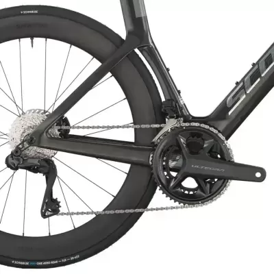 Detalhe da roda traseira e pedaleira de bicicleta de estrada em cinza escuro com componentes ULTEGRA e pneu SCHWALBE