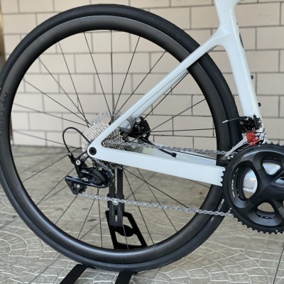 Roda traseira e componentes de uma bicicleta branca com sistema Shimano