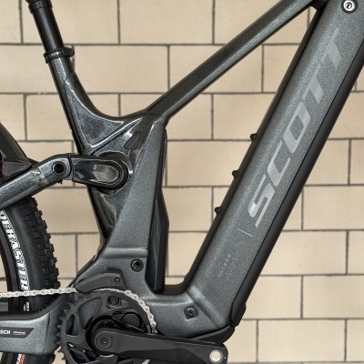 Quadro de bicicleta elétrica cinza metálico da marca SCOTT com corrente e pneu traseiro visíveis