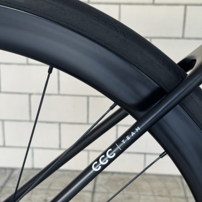 Roda e quadro preto de bicicleta com texto CCC TEAM