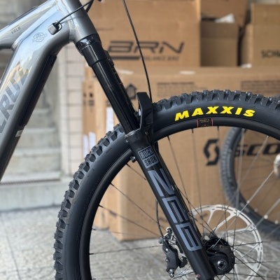 Quadro frontal de bicicleta cinzenta com suspensão dianteira e pneu MAXXIS