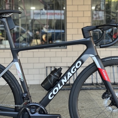 Bicicleta de estrada Colnago preto, branco e vermelho com rodas Pirelli e quadro em carbono