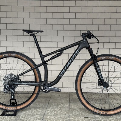 Bicicleta de montanha preta com pneus castanhos e marca SPECIALIZED no quadro