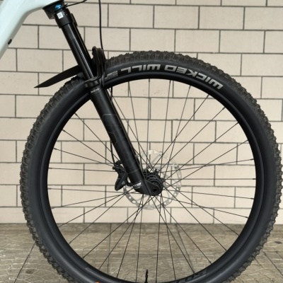 Roda dianteira de bicicleta preto com pneu Schwalbe num fundo de azulejos.