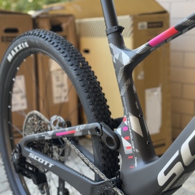Bicicleta de montanha Scott com quadro de carbono preto e detalhes em rosa e branco