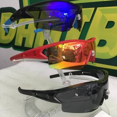 Três óculos de sol desportivos em suporte transparente com cores azul, vermelho e preto