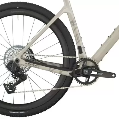 Parte traseira da bicicleta com quadro cinza e roda preta com pneu SCHWALBE G-ONE RX