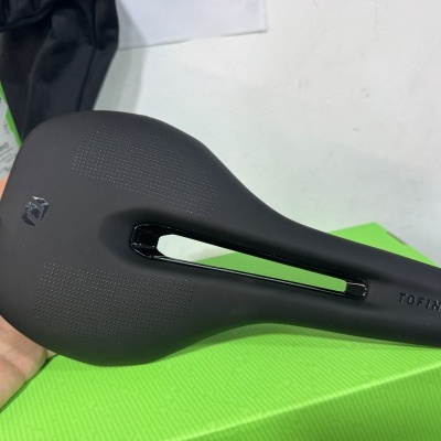 Selim de bicicleta preto com abertura central e palavra TOFINO
