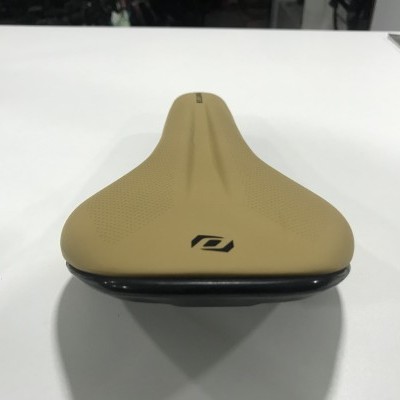 Selim bicicleta castanho com logo preto sobre superfície branca