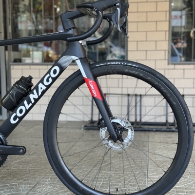 Bicicleta de estrada preta Colnago com roda dianteira Pirelli e travão de disco