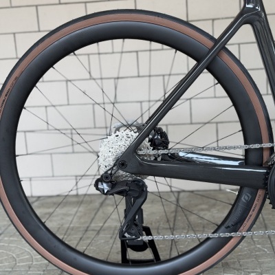 Roda de bicicleta de estrada com pneu castanho sobre suporte SCOTT