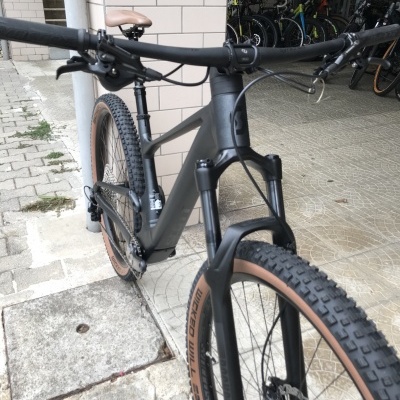 Bicicleta de montanha preta com pneus castanhos e selim castanho