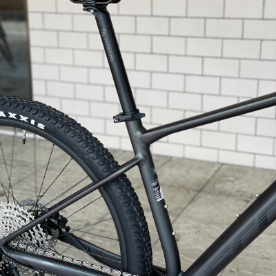 Bicicleta de montanha preta encostada a parede branca de azulejos