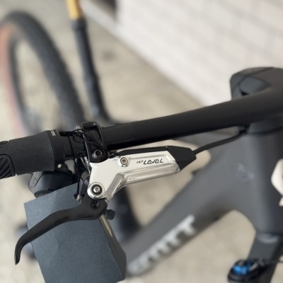 Punho de guiador de bicicleta com manete de travão prateada e inscrição ULT LEVEL.