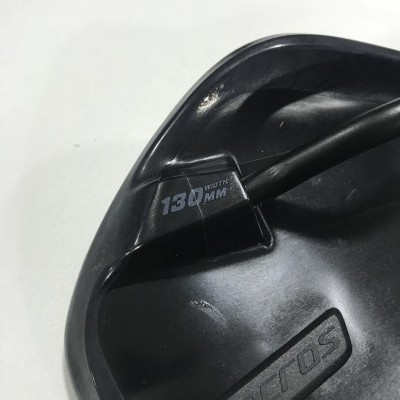 Assento de bicicleta preto com etiqueta '130 WIDTH MM' e marca 'syncros'.