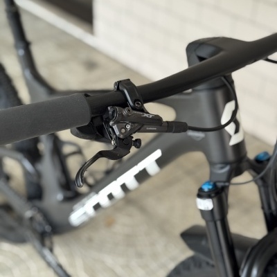 Bicicleta de montanha cinza escuro com componentes Shimano XT no guiador