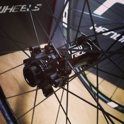 Roda de bicicleta preta com texto 'RIDE RACE' no cubo