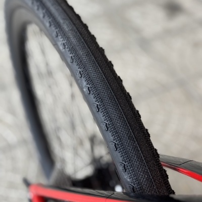 Pneu de bicicleta preto com padrão em relevo e aro vermelho