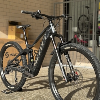 Bicicleta elétrica de montanha Scott preta com pneus Maxxis e suspensão Fox 34.