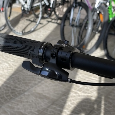 Punho e alavanca de mudança de velocidade preta de bicicleta com outras bicicletas em fundo