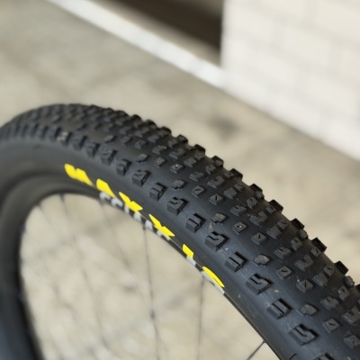 Pneu de bicicleta preto com letras amarelas Maxxis na lateral