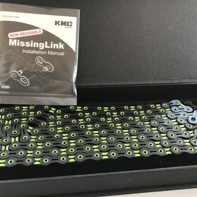 Cadeia de bicicleta preta com detalhes verdes numa caixa preta e manual de instalação KMC MISSINGLINK