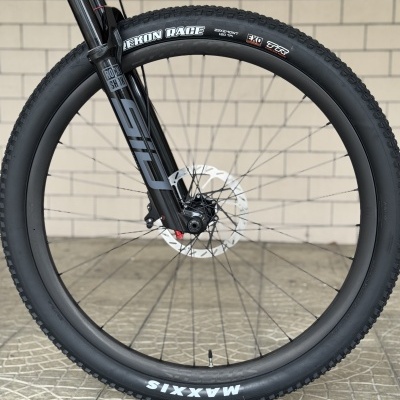 Roda de bicicleta preta com pneu Maxxis Rekon Race e suspensão RockShox