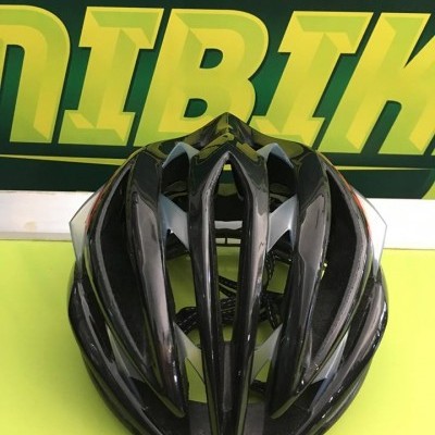 Capacete de bicicleta preto com aberturas em fundo verde e amarelo