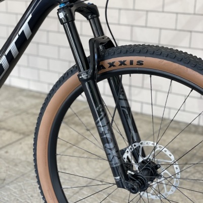 Roda dianteira de bicicleta de montanha com suspensão e pneu castanho Maxxis