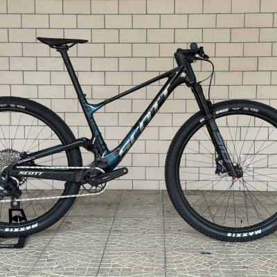Bicicleta de montanha preta e azul da marca SCOTT com pneus Maxxis Rekon Race